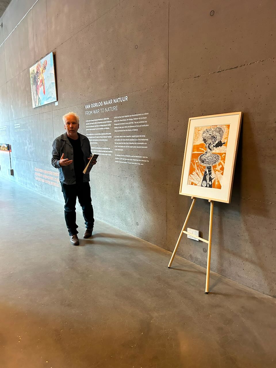Marcel van Kerkvoorde tijdens een rondleiding langs een linosnede uit MOED! Mijn soldaat in het Waterliniemuseum.